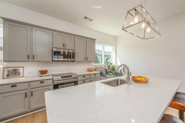 a living room with furniture a chandelier and kitchen view