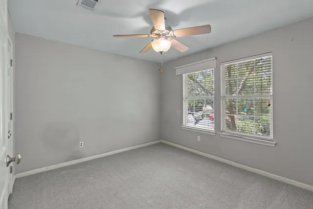an empty room with a window and a fan