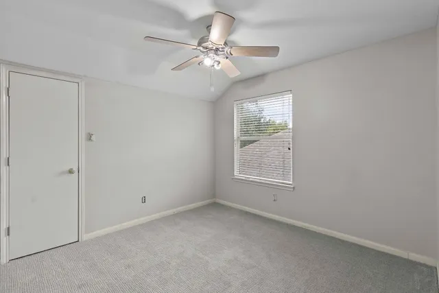 a view of a house with a yard and a large tree