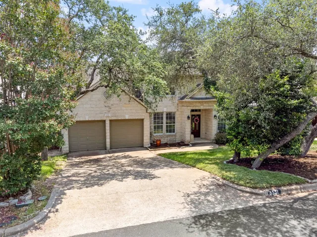 a front view of a house with a garden and yard