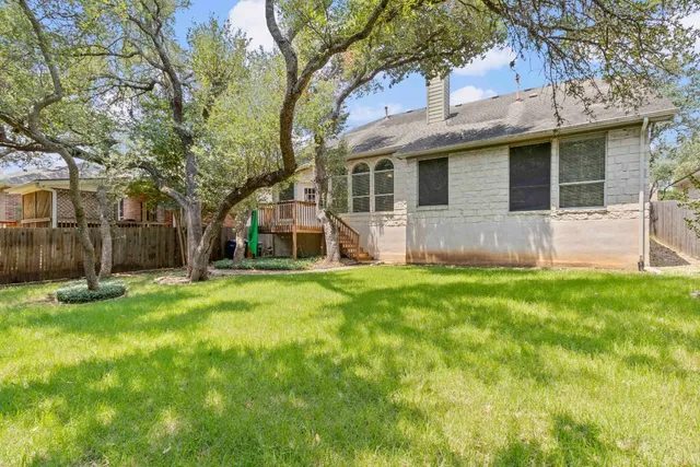 a view of a house with a yard and a large tree