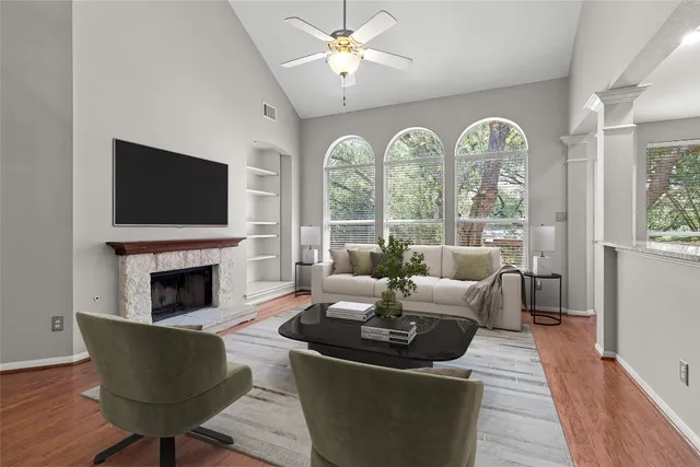 a living room with furniture fireplace and a large window
