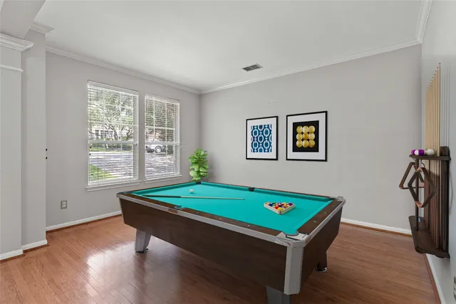 a room with pool table and windows