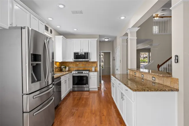 a large kitchen with granite countertop a large counter top appliances and stainless steel appliances