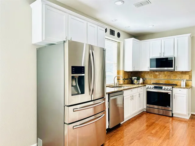 a kitchen with stainless steel appliances a refrigerator sink and microwave