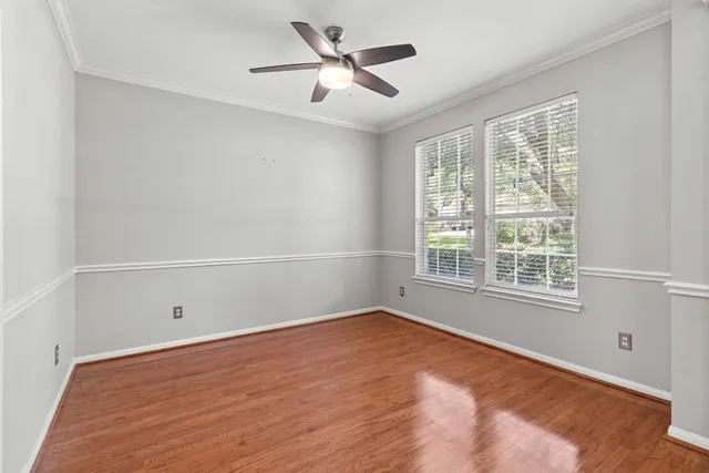 a view of a room with wooden floor and a ceiling fan