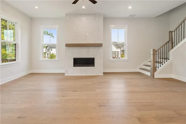 an empty room with windows and fireplace