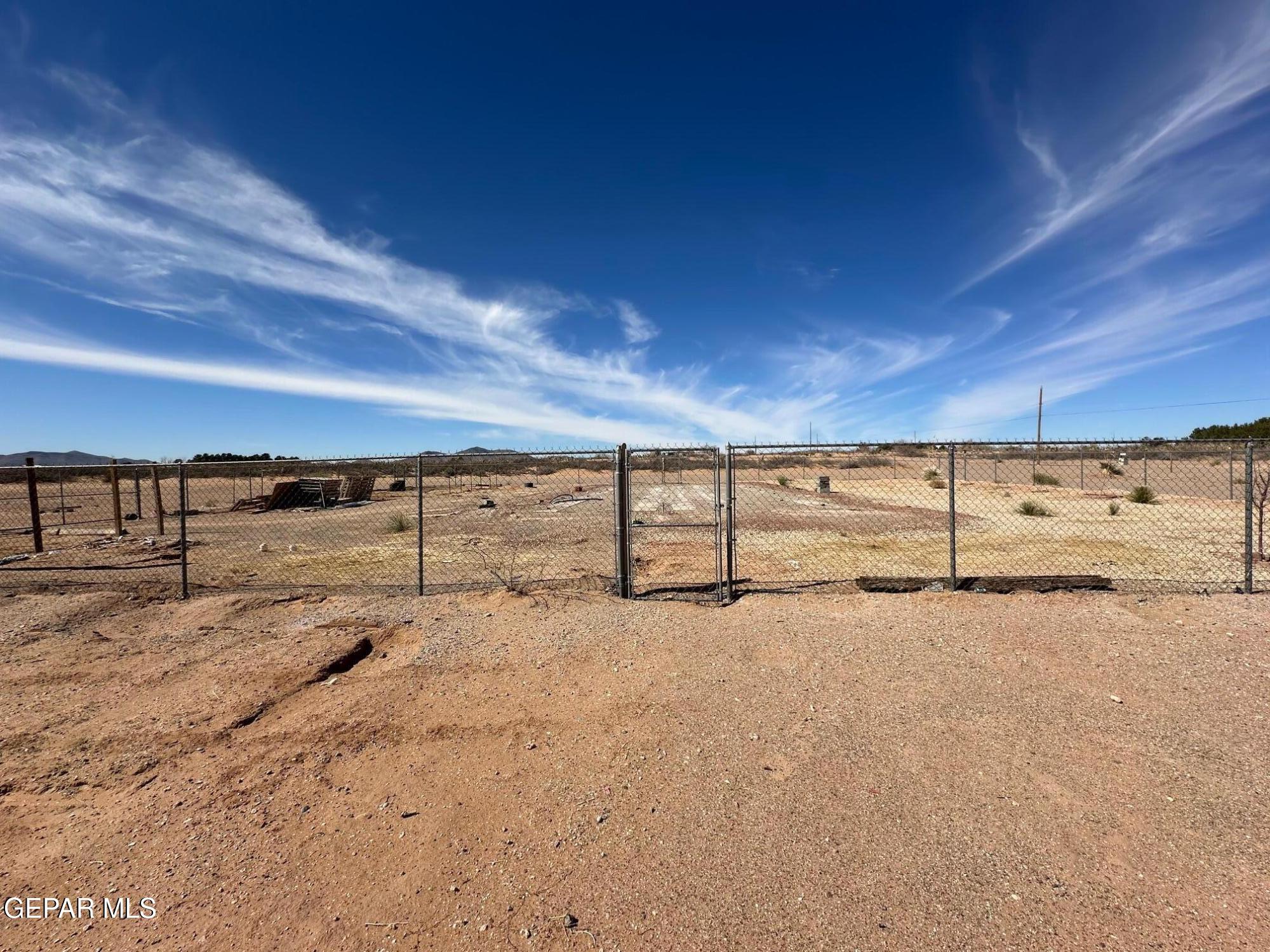 a view of a yard with wooden fence