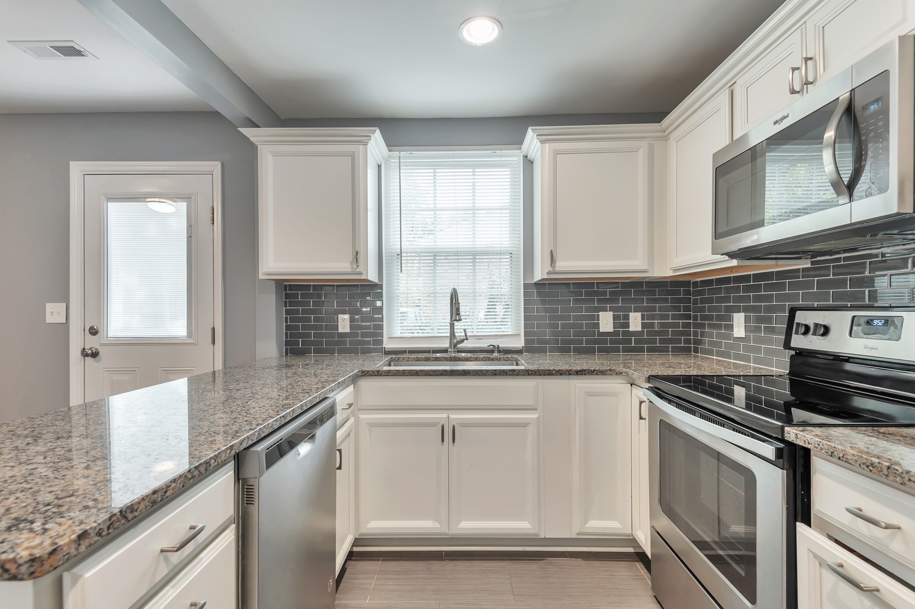 1301 Neelys Bend Road, Unit D27 Madison, TN 37115 - Photo 11 of 26 a kitchen with granite countertop white cabinets stainless steel appliances a sink and a window