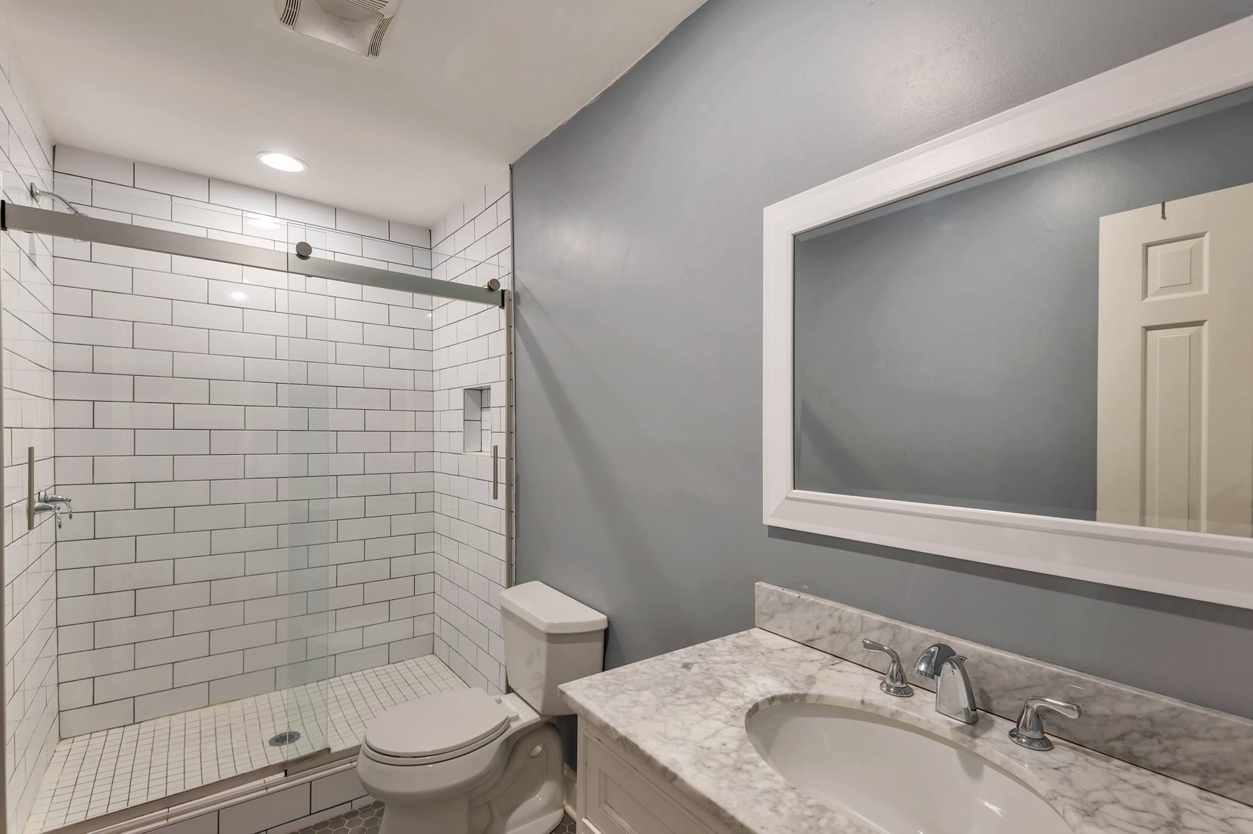 1301 Neelys Bend Road, Unit D27 Madison, TN 37115 - Photo 20 of 26 a bathroom with a granite countertop toilet a sink a mirror and shower