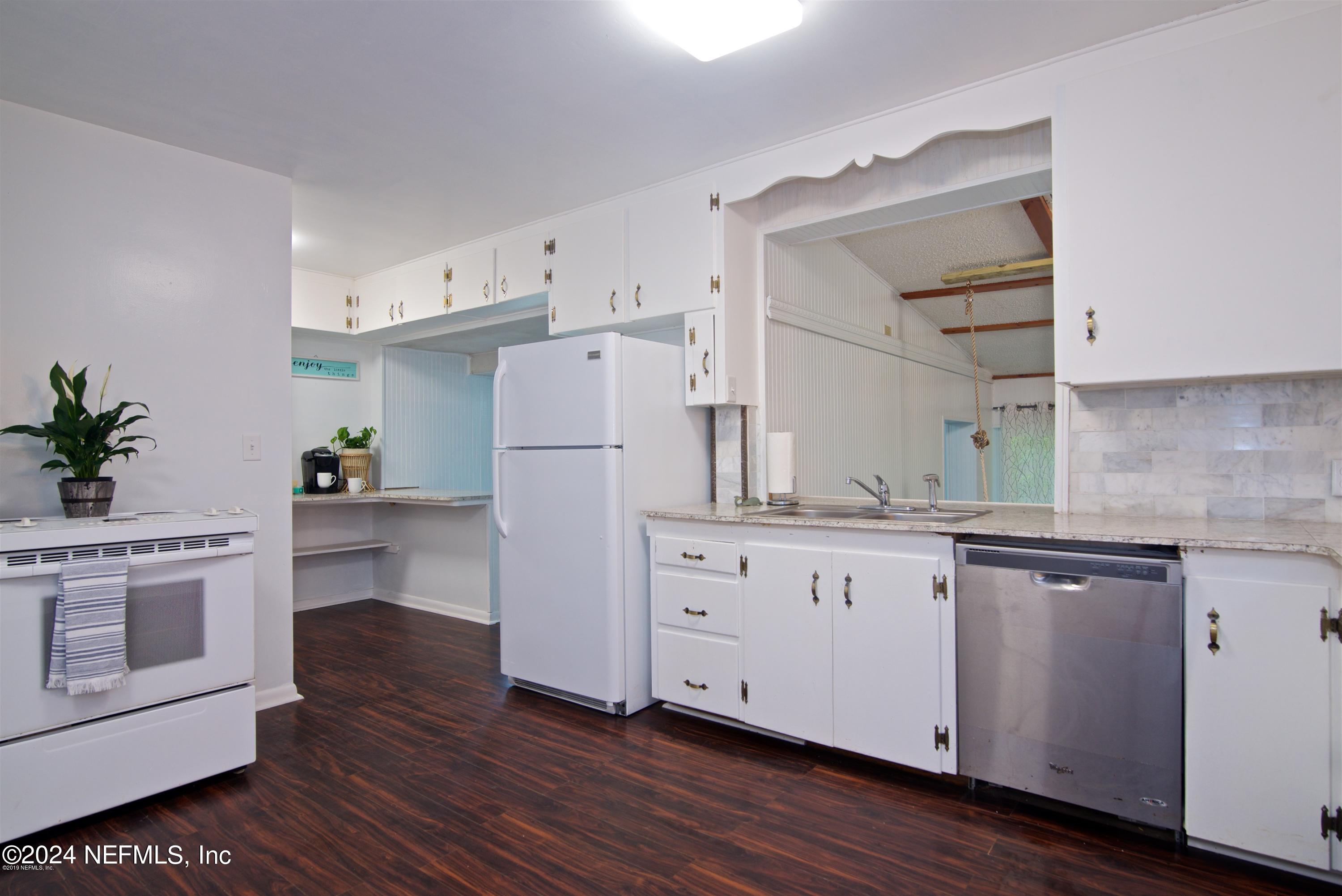 1938 Biggers Road Jacksonville, FL 32216 - Photo 12 of 25 a kitchen with white cabinets and white appliances