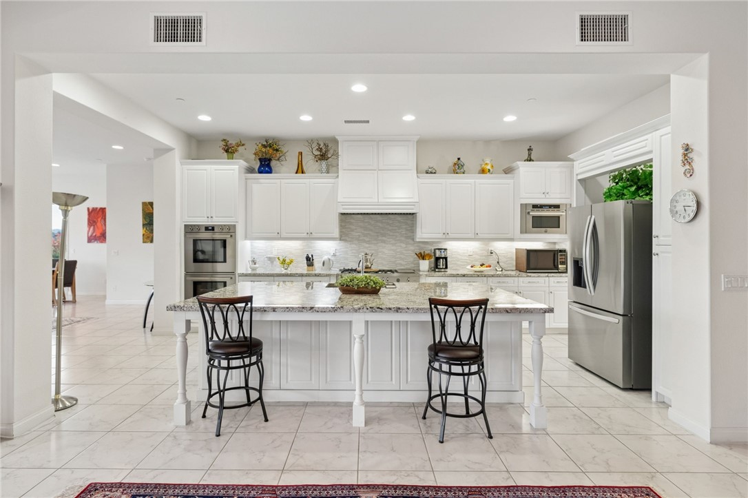 7774 Kingdom Drive Riverside, CA 92506 - Photo 20 of 66 a kitchen with a dining table chairs appliances and cabinets