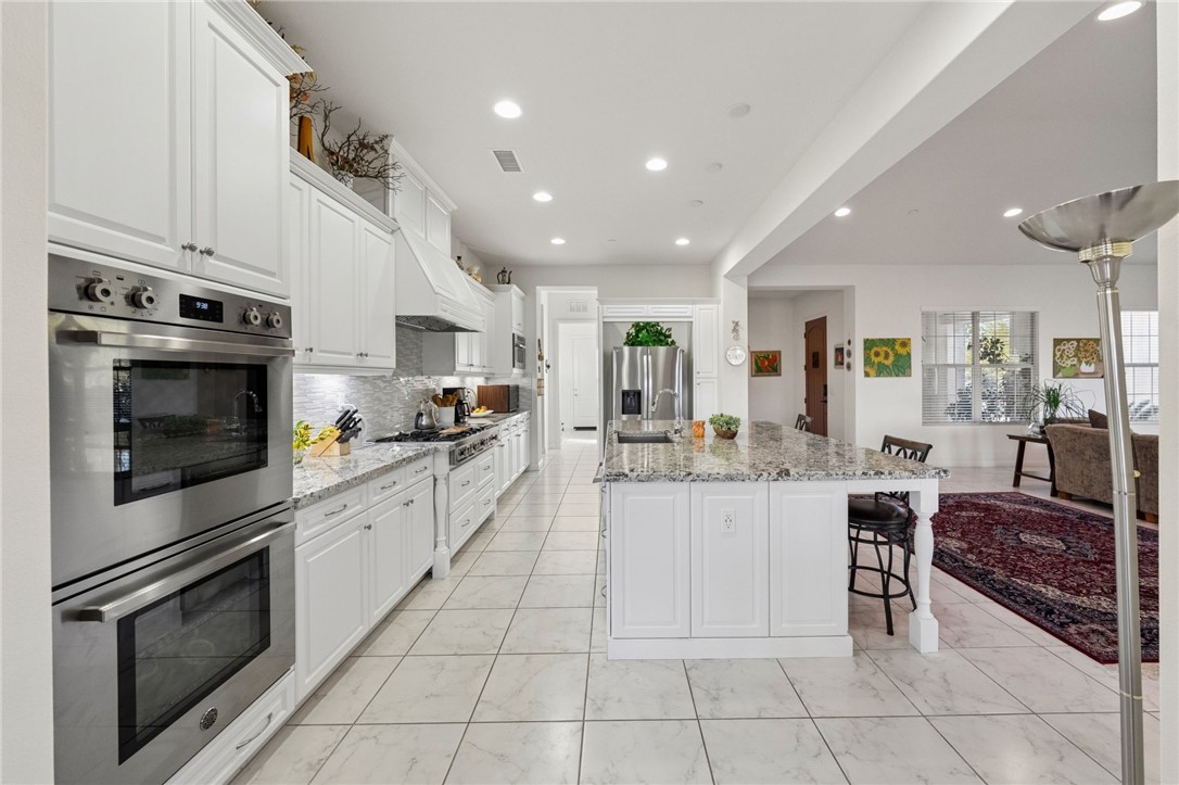 7774 Kingdom Drive Riverside, CA 92506 - Photo 21 of 66 a kitchen with stainless steel appliances kitchen island granite countertop a stove and cabinets