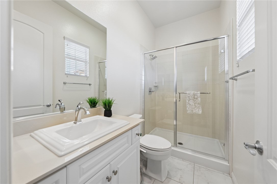 7774 Kingdom Drive Riverside, CA 92506 - Photo 46 of 66 a bathroom with a sink a toilet and shower