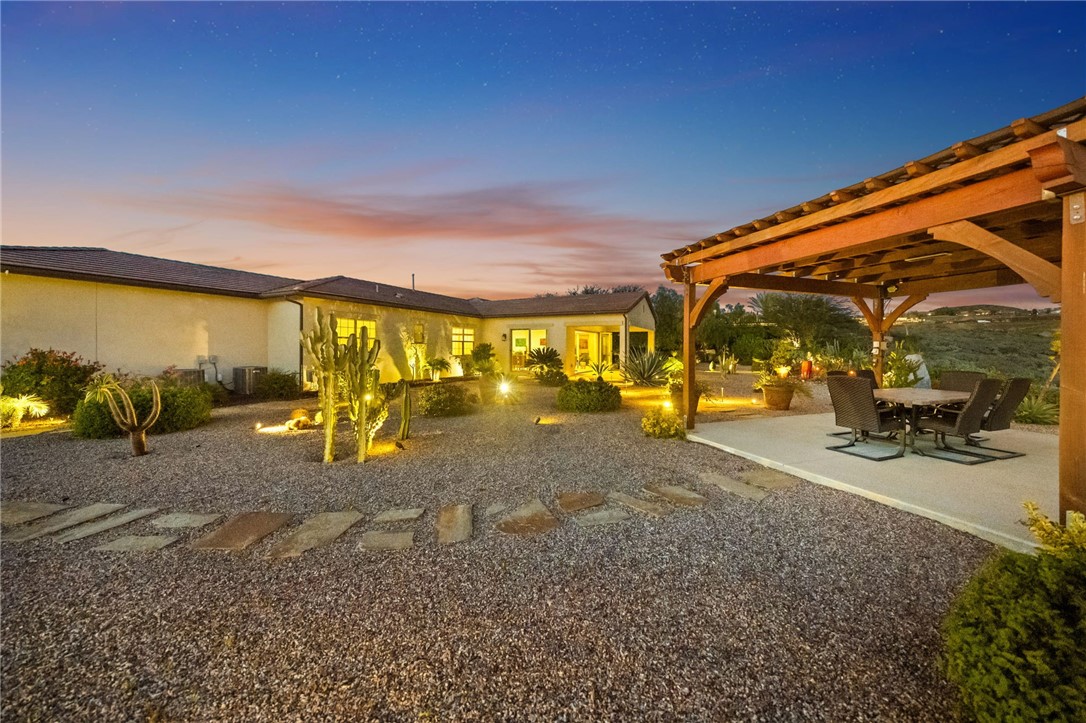 7774 Kingdom Drive Riverside, CA 92506 - Photo 63 of 66 Thoughtfully designed backyard features wide gravel pathways, accent lighting, and multiple areas to gather and unwind.