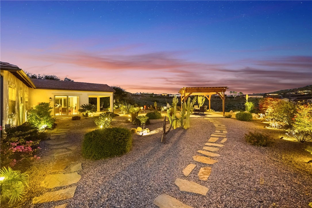 7774 Kingdom Drive Riverside, CA 92506 - Photo 10 of 66 Meandering stone paths, accent lighting, and drought-conscious landscaping create a warm and welcoming outdoor setting.