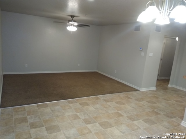 112 Lone Oak, Unit D102 Floresville, TX 78114 - Photo 12 of 34 en empty room with windows and fan