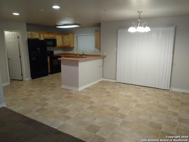 112 Lone Oak, Unit D102 Floresville, TX 78114 - Photo 9 of 34 a view of a kitchen with a sink and a refrigerator