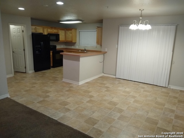112 Lone Oak, Unit D102 Floresville, TX 78114 - Photo 10 of 34 a kitchen with stainless steel appliances granite countertop a stove a sink and a refrigerator