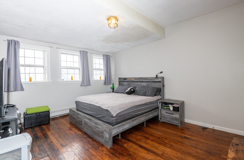 96 Derby Street, Unit 1 Salem, MA 01970 - Photo 12 of 31 a bedroom with a bed and a couch