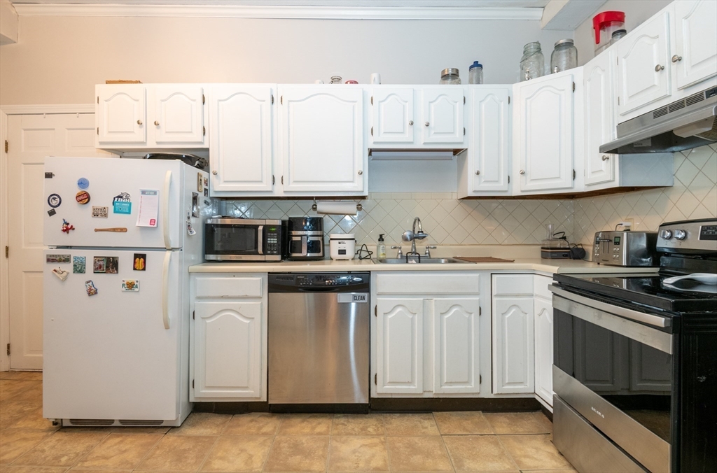 96 Derby Street, Unit 1 Salem, MA 01970 - Photo 6 of 31 a kitchen with stainless steel appliances granite countertop a sink a stove a refrigerator and white cabinets