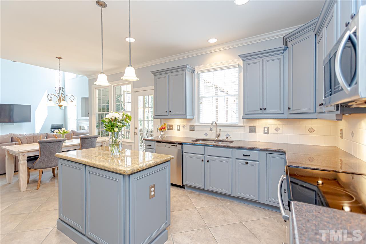 9408 Ray Road Raleigh, NC 27613 - Photo 11 of 30 a kitchen with kitchen island granite countertop stove sink and cabinets
