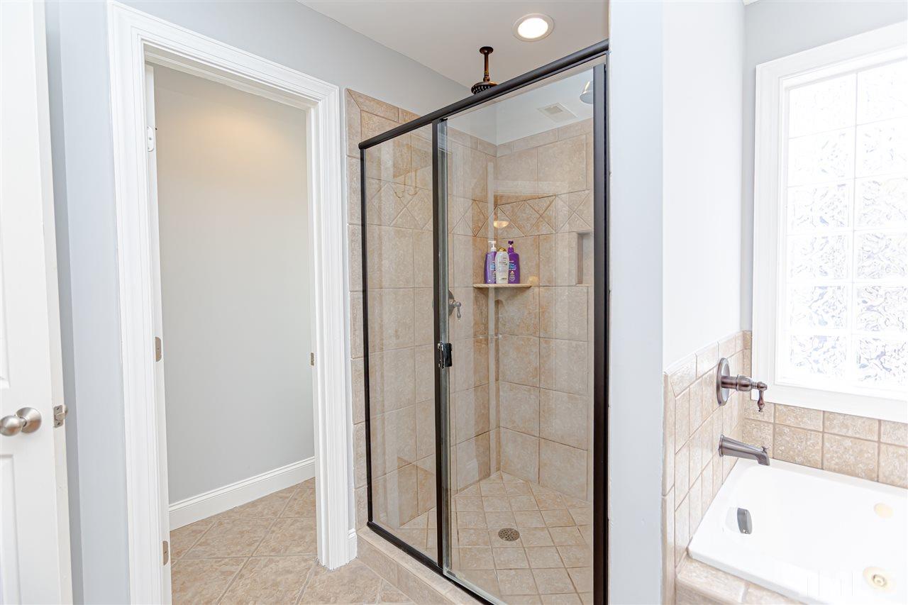9408 Ray Road Raleigh, NC 27613 - Photo 21 of 30 a bathroom with a bathtub and a shower