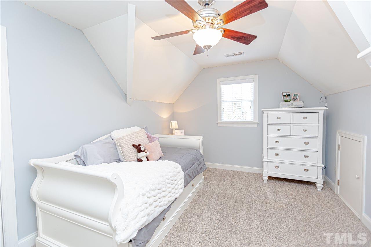 9408 Ray Road Raleigh, NC 27613 - Photo 25 of 30 a bedroom with a bed and a chandelier