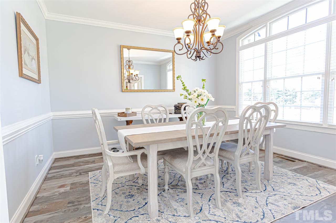 9408 Ray Road Raleigh, NC 27613 - Photo 6 of 30 a dining room with furniture a chandelier and wooden floor