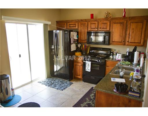 9353 Roping Cowboy Avenue Las Vegas, NV 89178 - Photo 4 of 22 Kitchen. CERAMIC TITLE KITCHEN FLOOR LEADING OUT TO THE 2ND FLOOR BALCONY. NOTHING BEHIND THEM