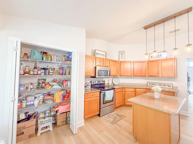 a kitchen with stainless steel appliances a stove a sink and a refrigerator with wooden floor