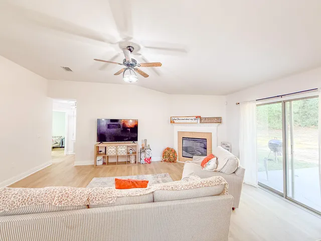 a living room with furniture a fireplace and a flat screen tv