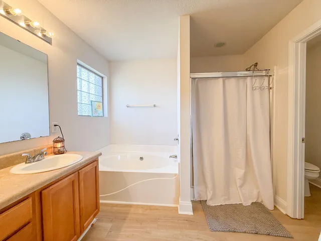 a spacious bathroom with a tub sink and shower