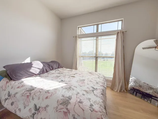 a large bed sitting in a bedroom next to a window