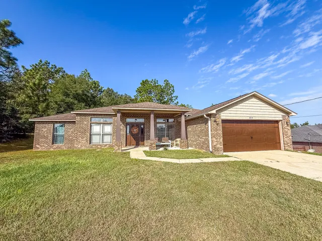 a view of a house with a yard and garage