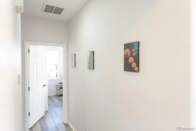 a view of a hallway with wooden floor
