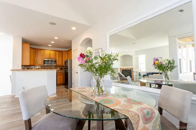 a dining room filled chandelier and kitchen view