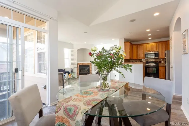 a view of a dining room with furniture a potted plant and wooden floor