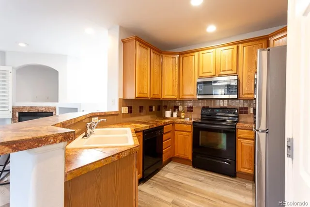a kitchen with stainless steel appliances granite countertop a stove a sink and a microwave