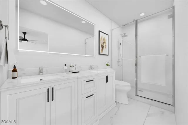 a bathroom with a double vanity sink mirror and toilet