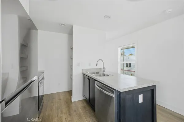 a kitchen with a sink cabinets and wooden floor
