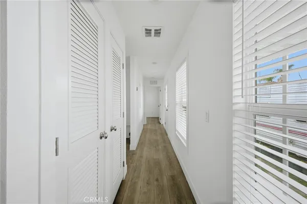 a view of a hallway with wooden floor and staircase