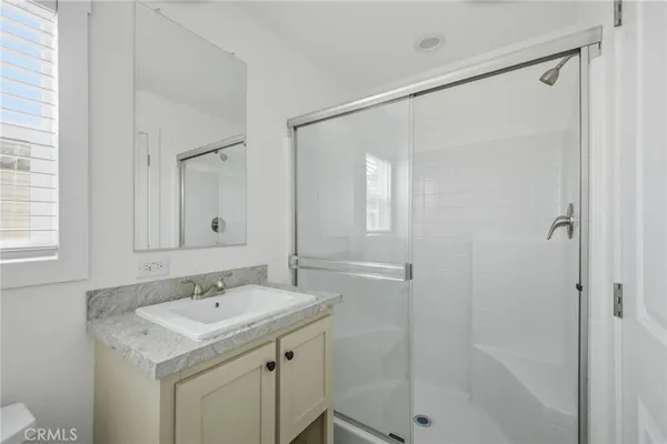 a bathroom with a shower sink vanity and mirror