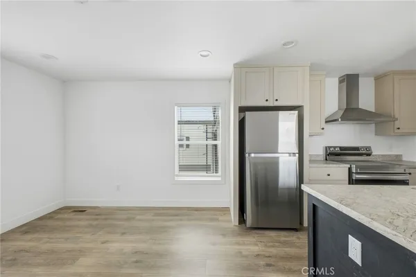 a kitchen with stainless steel appliances granite countertop a refrigerator a stove and a sink