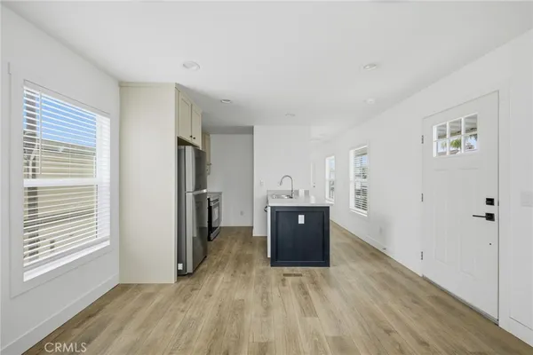 a view of a kitchen with refrigerator and wooden floor