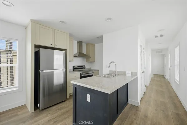 a kitchen with a sink a refrigerator and cabinets