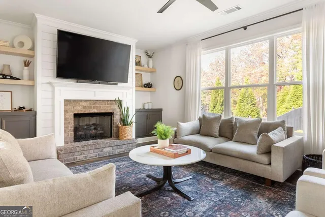 a living room with furniture a fireplace and a flat screen tv