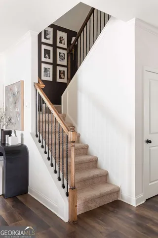 a view of staircase with lots of frames on wall and a painting on the wall