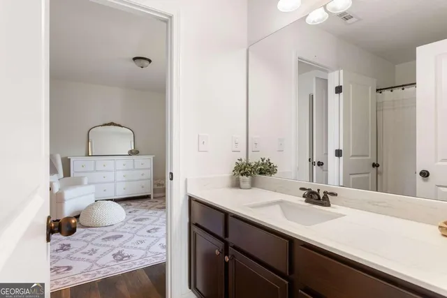 a bathroom with a granite countertop sink and a mirror