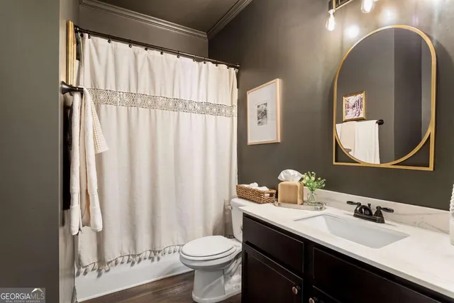 a bathroom with a double vanity sink toilet and a mirror